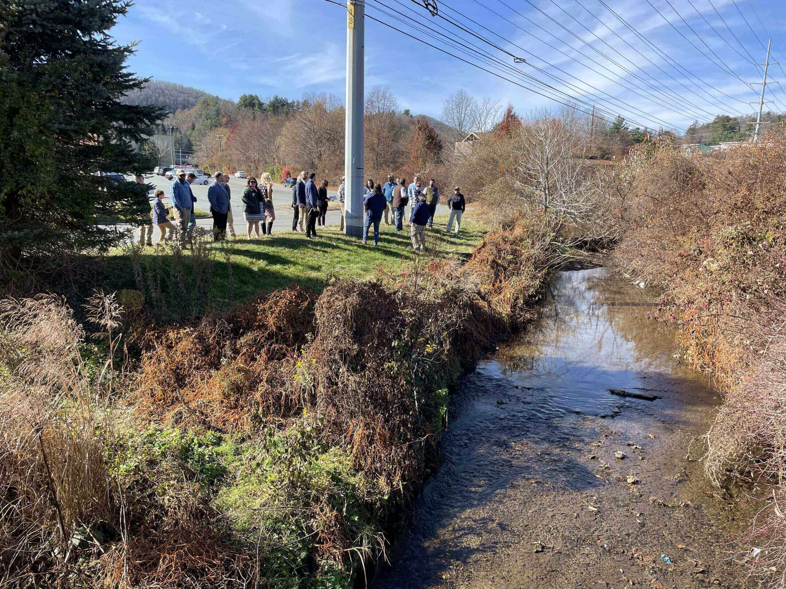 people standing on stream bank